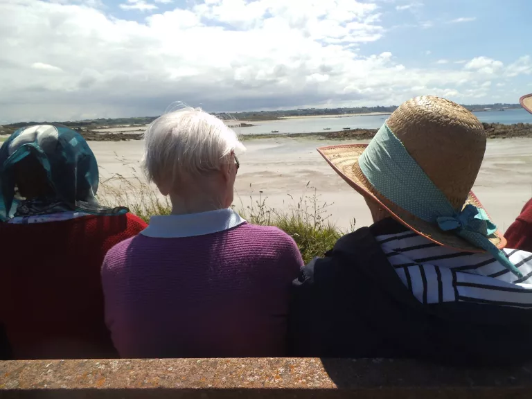 trois personnes âgées face à la plage